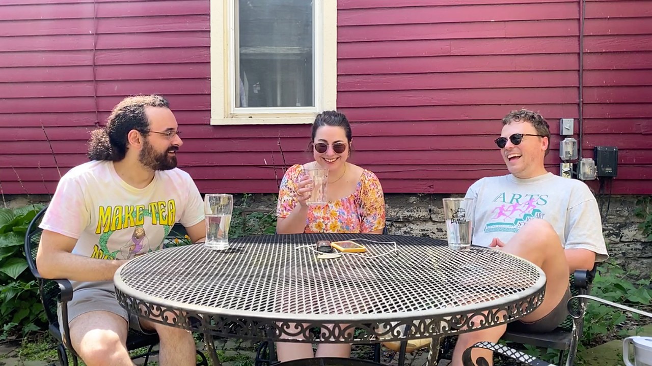 Jordan, Amanda Bintz, and Peter Hanley laughing around a garden table
