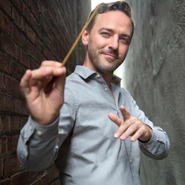 Charles Czarnecki holding a conductor&rsquo;s baton