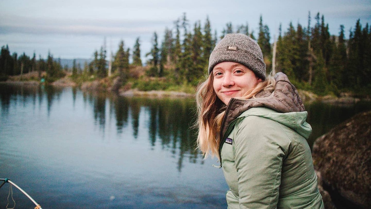 Chelsea Newton beside a mountain lake